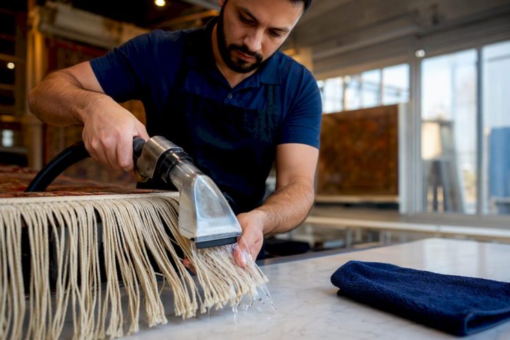 Technician rinsing fragile rug fringe